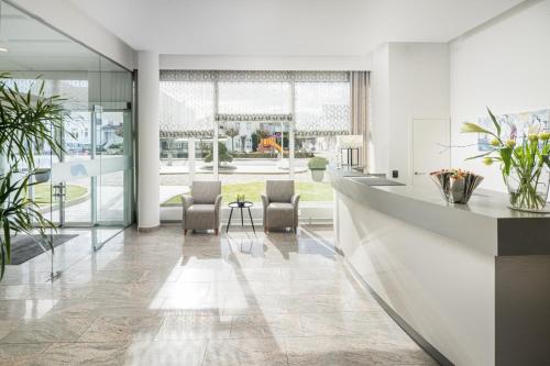 a lobby with two chairs and a table at Hotel Bellevue in Timmendorfer Strand