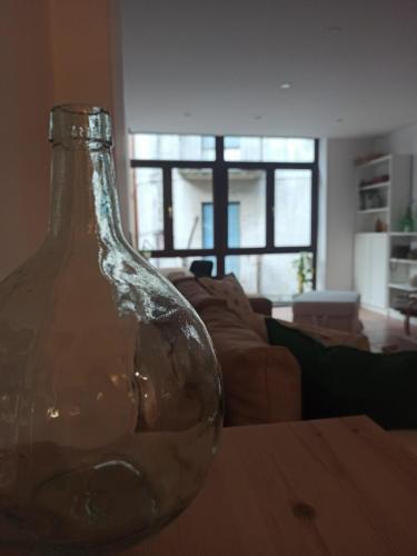 a glass bottle sitting on a table in a living room at La Casita del Camino in Redondela