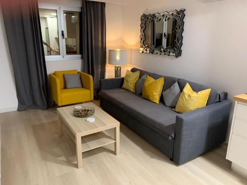 salon z szarą kanapą i żółtym krzesłem w obiekcie Rociaga 35 Apartment 8, 100 meters to sea front w Puerto del Carmen