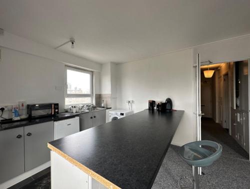una cucina con piano di lavoro nero in una camera di Spacious,1 bed, balcony, Southwark Central London a Londra