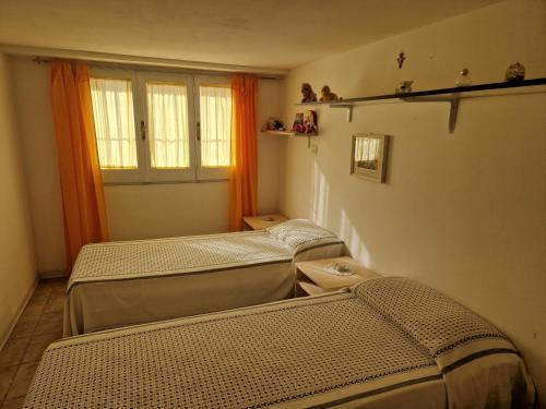 3 Betten in einem Zimmer mit orangefarbenen Vorhängen in der Unterkunft Tavernetta Giuseppe Verdi in Ugento