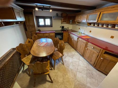 a large kitchen with a wooden table and chairs at Casa Botiza - Cătun in Sinaia