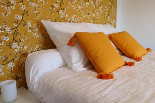 ein weißes Bett mit zwei Kissen darüber in der Unterkunft Lodge de la Vigneronne in Châtillon-sur-Marne