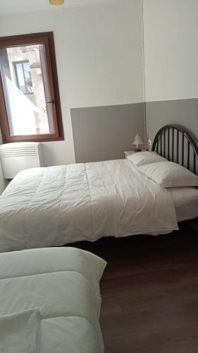 2 letti bianchi in una camera da letto con finestra di Casa Belzoni a Padova