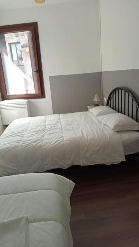 2 białe łóżka w sypialni z oknem w obiekcie Casa Belzoni w Padwie