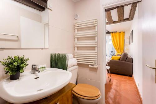 a bathroom with a sink and a toilet and a couch at Sweety home in center of Paris in Paris