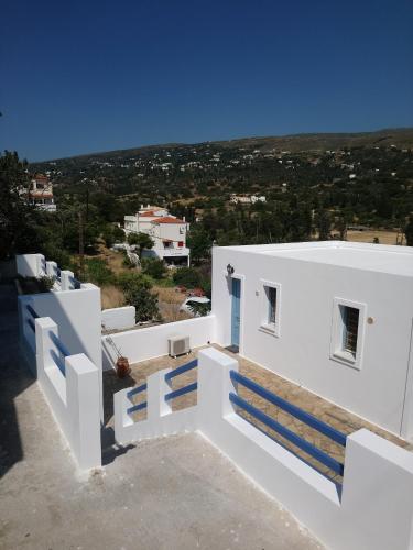 una vista desde la parte superior de una casa blanca con escaleras azules en Andros Guesthouses, en Ándros