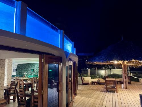 un restaurante con terraza con mesas y sillas por la noche en Zula Zanzibar, en Paje