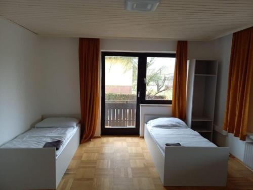 two beds in a room with a large window at Arbeiterquartier in Lebring