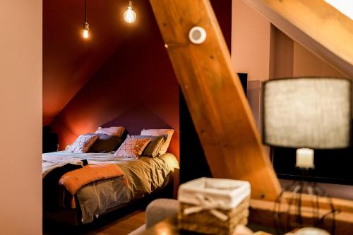 um quarto com uma cama e um tecto em madeira em L'Evasion em Nolay