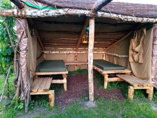 dwie ławki siedzące w namiocie w obiekcie Au Pied Du Trieu, The Shelter w mieście Labroye