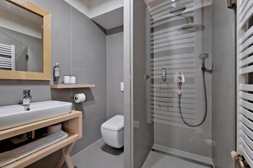 a bathroom with a shower and a sink and a toilet at Monte House Apartments Odkryj Zakopane in Zakopane