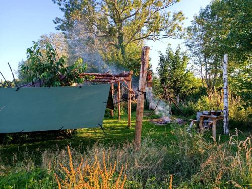 un barco sentado en un campo junto a una valla en Au Pied Du Trieu, The Shelter, en Labroye