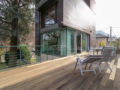 a wooden deck with a chair and a table on it at Mamma Ciccia - ecofriendly villa on Lake Como in Malgrate