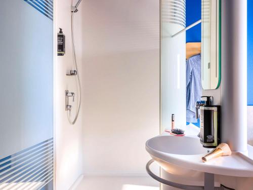 a white bathroom with a sink and a mirror at Ibis budget Lausanne-Bussigny in Lausanne