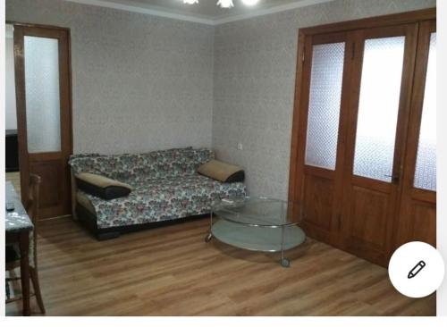 Habitación con cama y mesa de cristal. en улица Абазгаа Апартаменты en Gagra