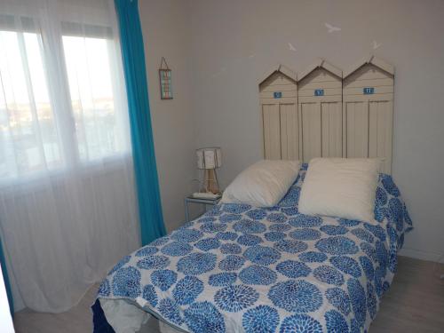 une chambre avec un lit avec une couette bleue et blanche dans l'établissement Appartement T3, 6 couchages, Le Montreuil, Narbonne Plage, à Narbonne-Plage