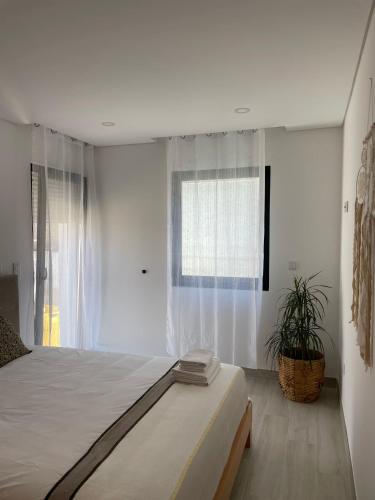 um quarto branco com uma cama e uma janela em Porto Smart Apartments Comfort em Perafita