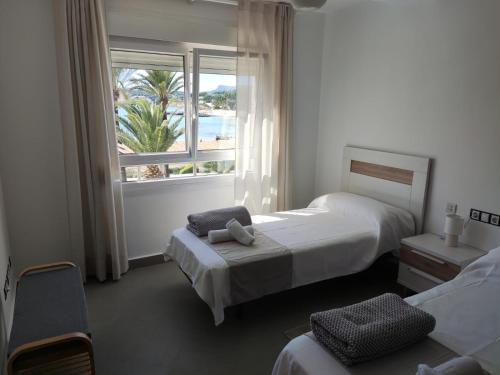 a hotel room with two beds and a window at Moraira Beach 1 in Moraira