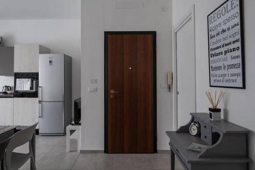 a kitchen with a refrigerator and a wooden door at Casa Alessia Appartamento Confortevole in Gassino Torinese
