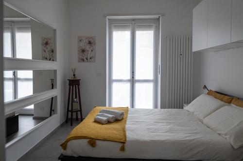 a white bedroom with a bed with two towels on it at Casa Alessia Appartamento Confortevole in Gassino Torinese
