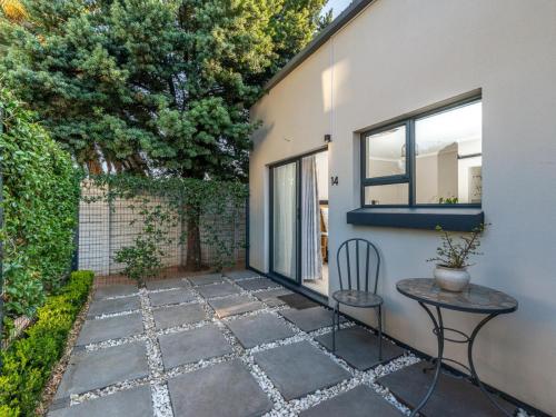 a patio with a table and a chair next to a building at Magnolia Guesthouse in Alberton