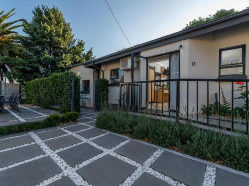 a building with a sidewalk in front of it at Magnolia Guesthouse in Alberton
