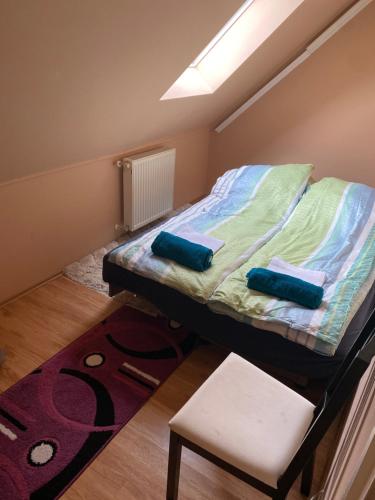 1 dormitorio con 1 cama, 1 silla y 1 alfombra en Újszerű, jól felszerelt lakás a város szîvében, ingyenes parkolással!, en Debrecen