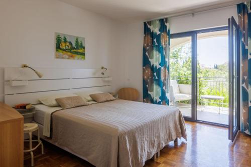 1 dormitorio con 1 cama grande y balcón en Rooms and Apartments Mofardin, en Rovinj