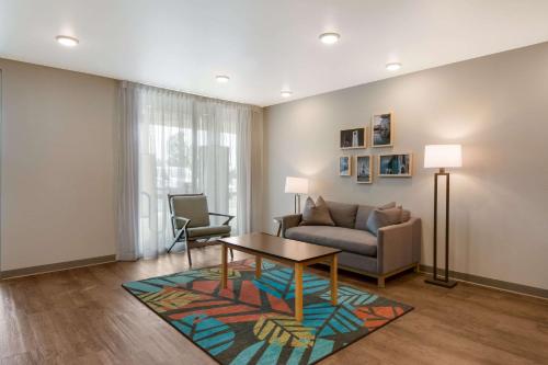 a living room with a couch and a table at WoodSpring Suites Morrisville - Raleigh Durham Airport in Morrisville