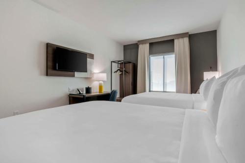 a hotel room with two beds and a flat screen tv at Comfort Inn & Suites Panama City Beach - Pier Park Area in Panama City Beach