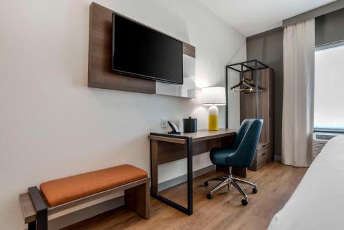 a hotel room with a desk and a tv and a chair at Comfort Inn & Suites Panama City Beach - Pier Park Area in Panama City Beach