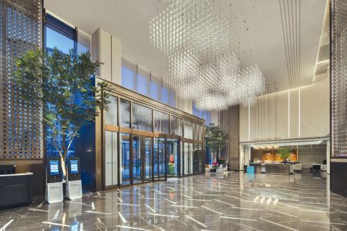 a lobby of a building with a chandelier at Wyndham Xiong'an in Baoding