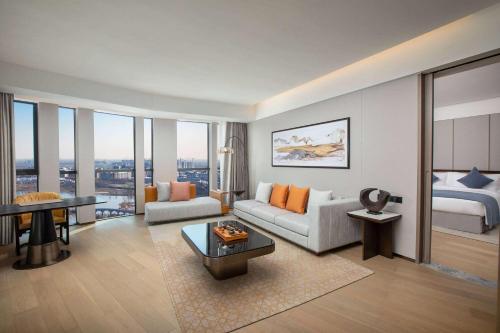 a living room with a couch and a bed at Wyndham Xiong'an in Baoding