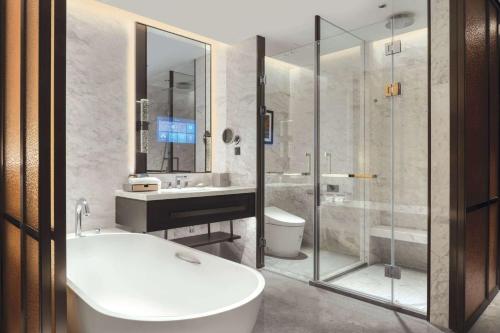 a bathroom with a tub and a sink and a toilet at Wyndham Xiong'an in Baoding