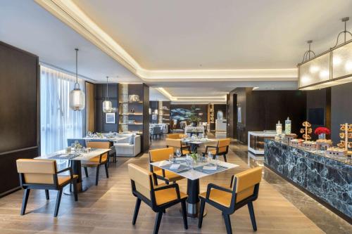 a restaurant with tables and chairs and a bar at Wyndham Xiong'an in Baoding