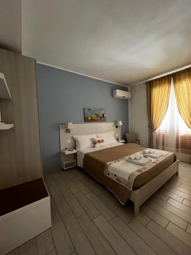 a bedroom with a large bed and a window at Cima Bianca in San Vito lo Capo