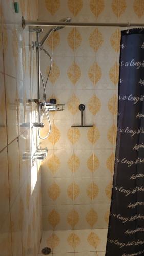 a shower in a bathroom with a tiled wall at Orimar in San Felipe de Puerto Plata