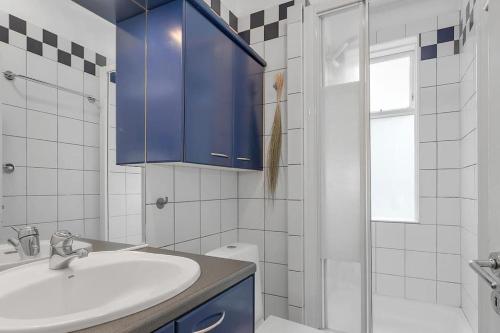 een badkamer met een wastafel en een blauwe kast bij Cosy apartment in the old west Reykjavik center in Reykjavík