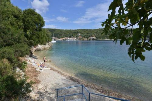 a person sitting on a beach near the water at Argalios Studios in Kiónion