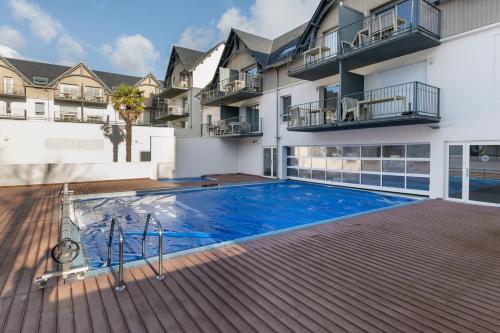 une piscine devant un immeuble dans l'établissement L'Arvor - Appt piscine et sauna partagés, à Bénodet
