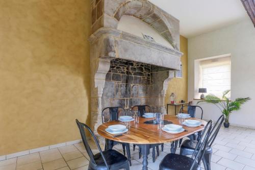 une salle à manger avec une table et des chaises et une cheminée dans l'établissement Tour des Alleux - Maison de maître pour 6, à Taden