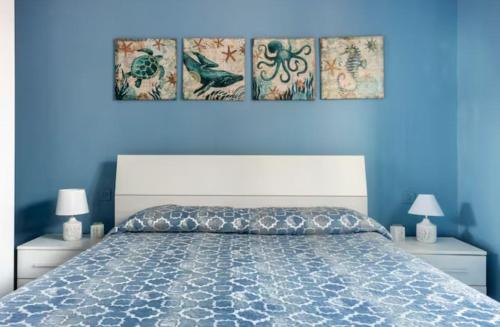 ein Schlafzimmer mit einem großen Bett mit blauen Wänden in der Unterkunft Casa Davide in Sottomarina