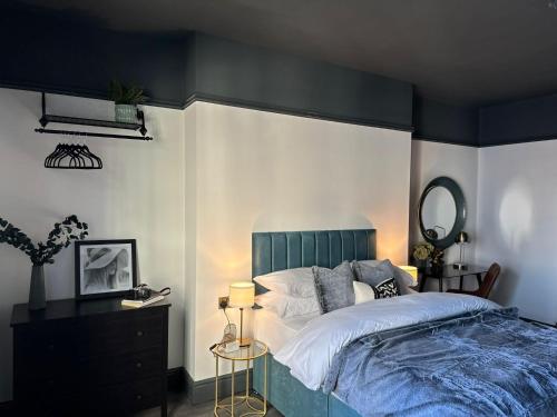 a bedroom with a large bed with a green headboard at Warwick St Studios in Leamington Spa