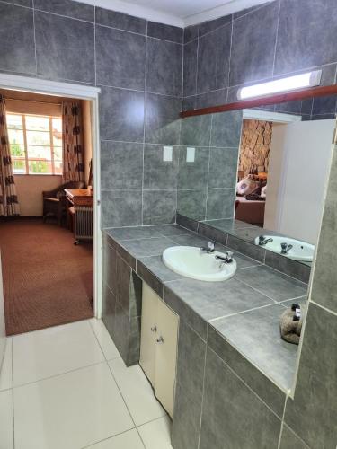 a bathroom with a sink and a mirror at Gooderson Leisure Mountain View Cottages Self Catering Resort in Drakensberg Garden