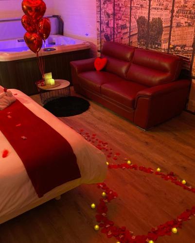 1 dormitorio con cama, sofá y globos en L'Evasion chambre MONTMARTRE avec Jacuzzi privatif en Prinquiau