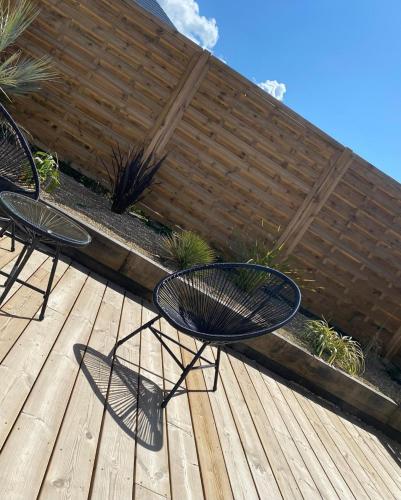 two black chairs sitting on a wooden deck at L'Evasion chambre MONTMARTRE avec Jacuzzi privatif in Prinquiau