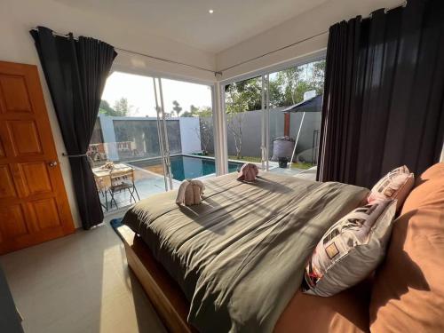 a bedroom with a bed and a large window at Sand House in Chaweng