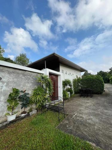 a white building with a red door and some plants at Sand House in Chaweng