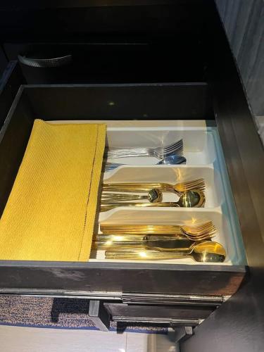 a drawer filled with silver utensils and a book at Sand House in Chaweng